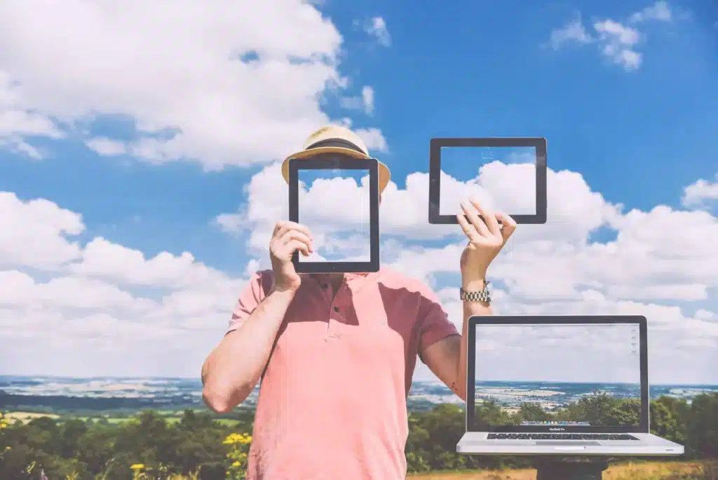 Person holding tablets up against a cloudy sky to illustrate cloud storage